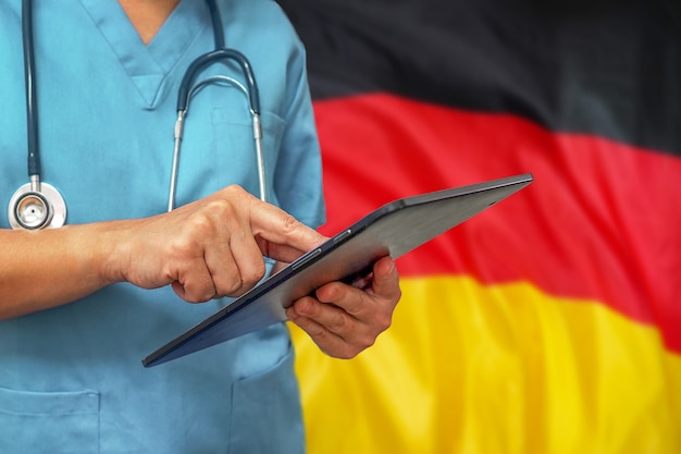 Surgeon or doctor using a digital tablet on the background of the Germany flag