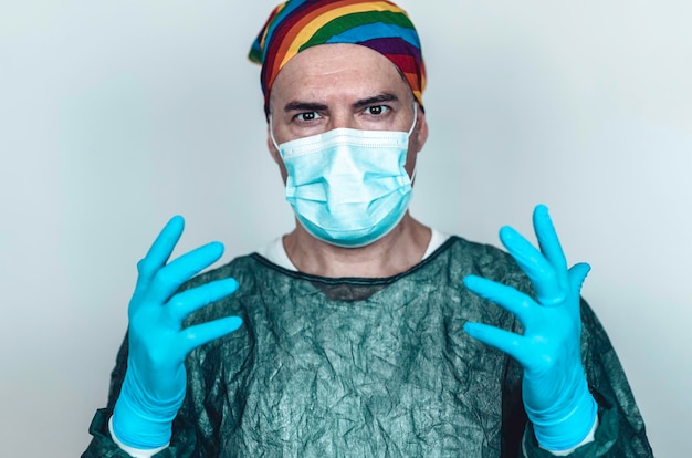 Surgeon doctor wearing protective mask blue gloves and rainbow bandanna on his head Specialist doctor who fights for gay and lgbtq people rights hiv virus or coronavirus prevention