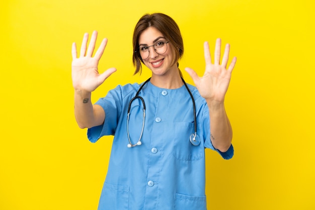 Surgeon doctor woman isolated on yellow background counting ten with fingers