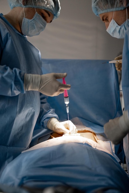 Surgeon makes an injection during an operation