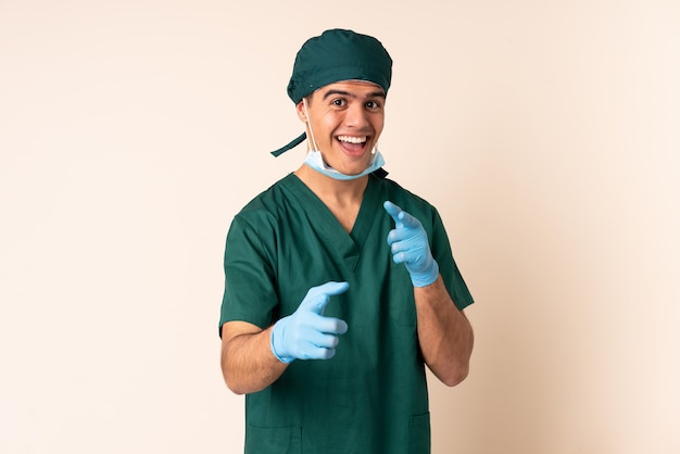 Surgeon man in blue uniform over isolated points finger at you