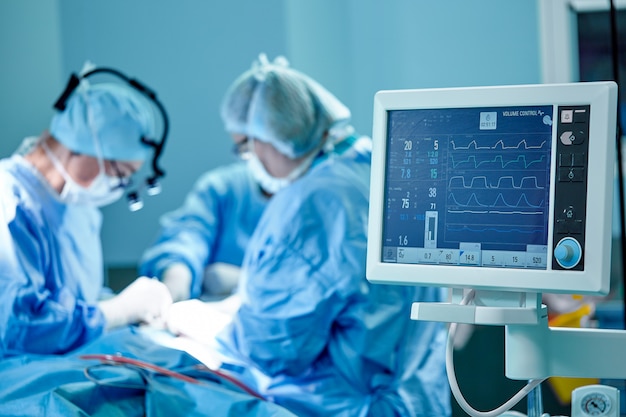 A surgeon's team in uniform performs an operation on a patient at a cardiac surgery clinic. Modern medicine, a professional team of surgeons, health.