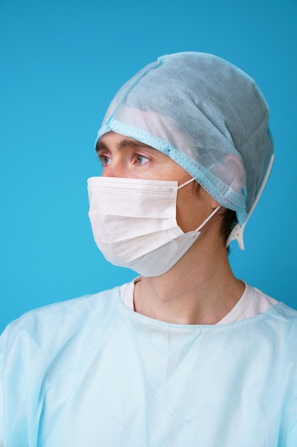 Surgeon in sterile blue uniform medical gloves and mask