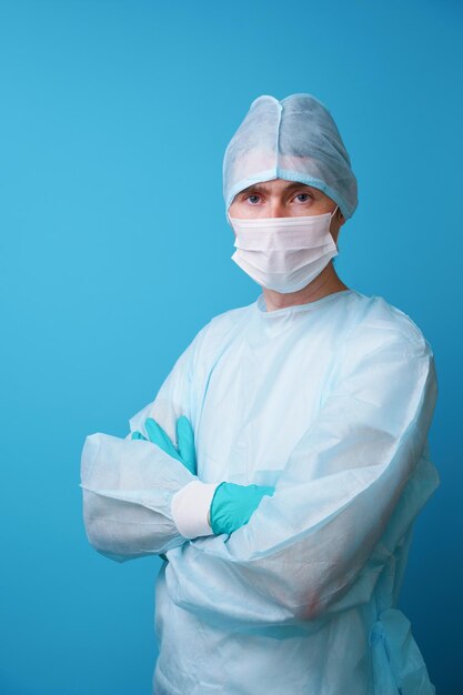 Surgeon in sterile blue uniform medical gloves and mask