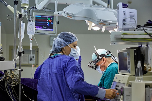 A surgeon with assistants performs an operation in a modern hospital. Medical team performing operation.