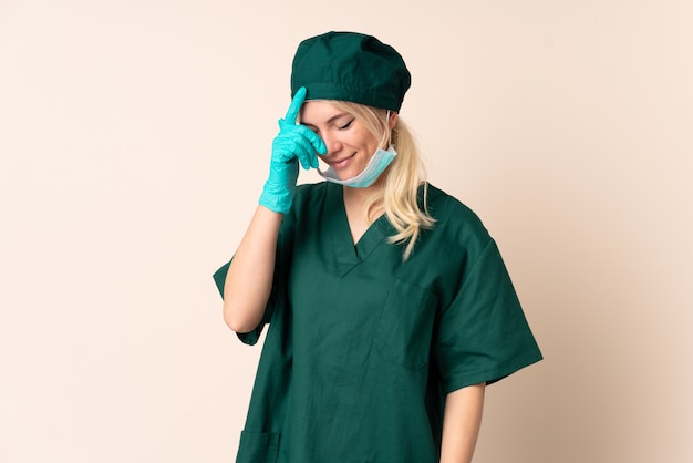 Surgeon woman in green uniform over isolated  laughing