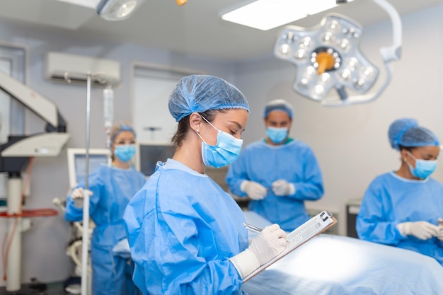 Surgeon writing on clipboard in operation room anaesthesiologist writing the updates