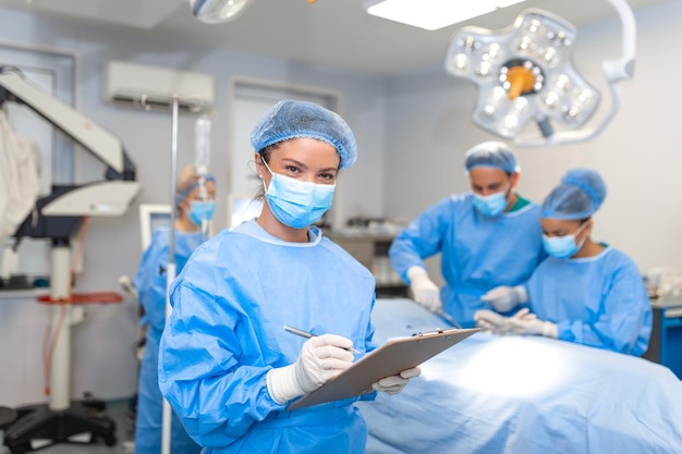 Surgeon writing on clipboard in operation room anaesthesiologist writing the updates