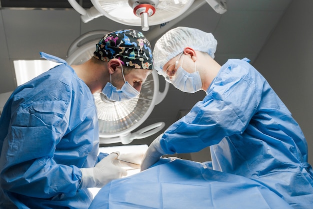 Surgeons do plastic operation in medical clinic. Correcting form of face for patient