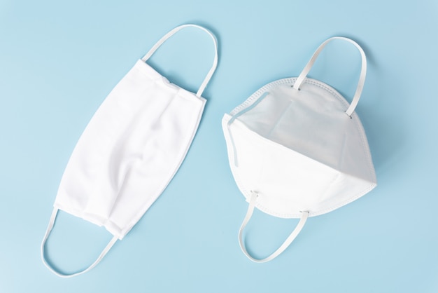 Surgical and cloth masks  on soft blue background