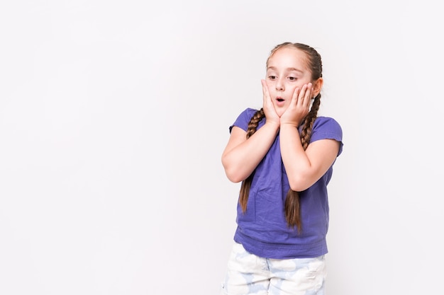 Surorised child girl isolated on white background. Beautiful caucasian model.