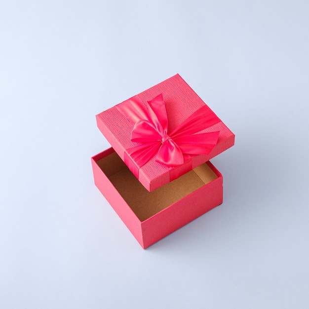 Surprise in a gift box with a ribbon. Minimal pastel concept with levitation of gift and event.