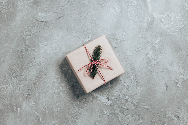 Surprise gift box wrapped in craft paper with spruce branch