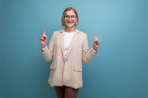 Surprised adult woman with a bob hairstyle in a classic jacket points to the side on a bright