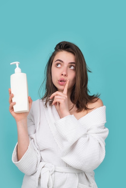 Surprised amazed woman hold bottle shampoo and conditioner