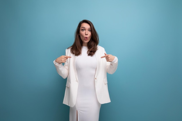 Surprised brunette woman in dress with blue copyspace