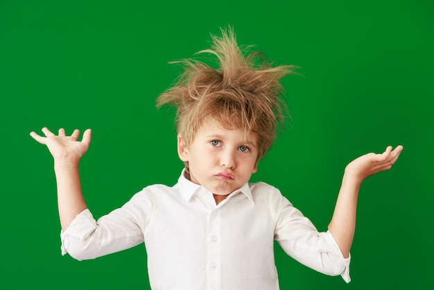 Surprised child against green chalkboard in class