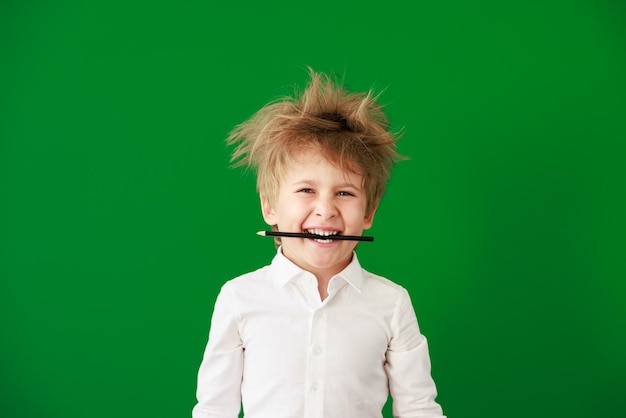 Surprised child against green chalkboard in class