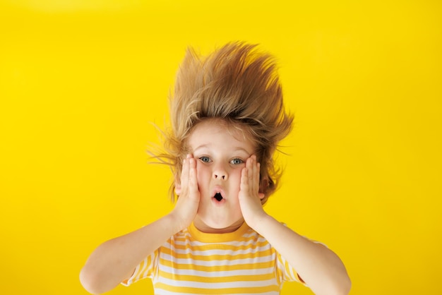 Surprised child against yellow background