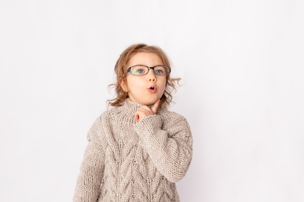 Surprised child girl with glasses on white background, space for text