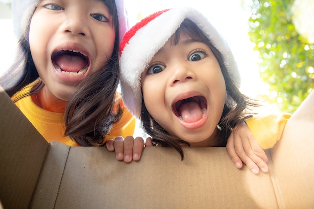 Surprised children unpack Christmas gift box