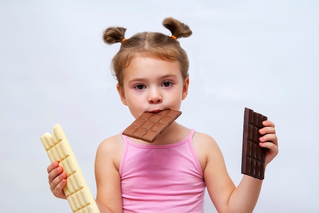 Surprised funny little girl holding chocolate and looking.