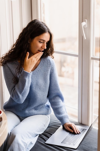 Surprised girl is winning bet in online casino and feeling happy Shocked girl with laptop is looking on the amount of earnings in online cash game