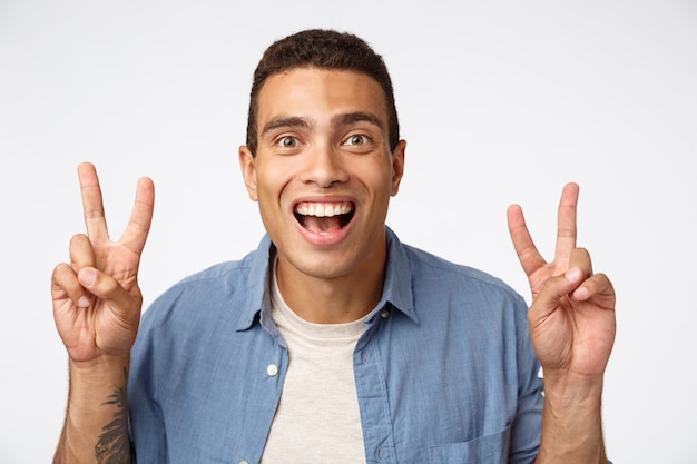 Surprised, handsome masculine young hispanic guy in shirt over t-shirt