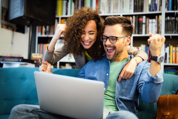 Surprised happy couple looking at laptop together