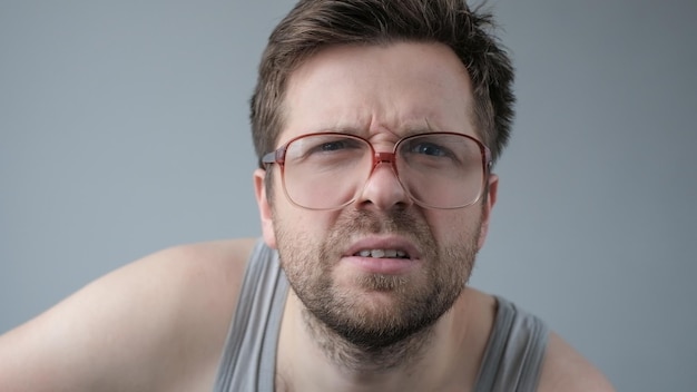 Surprised man in big glasses with wow expression on gray backgound