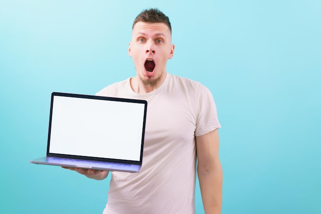 surprised man holding a laptop with an empty blank screen and looking with an open mouth