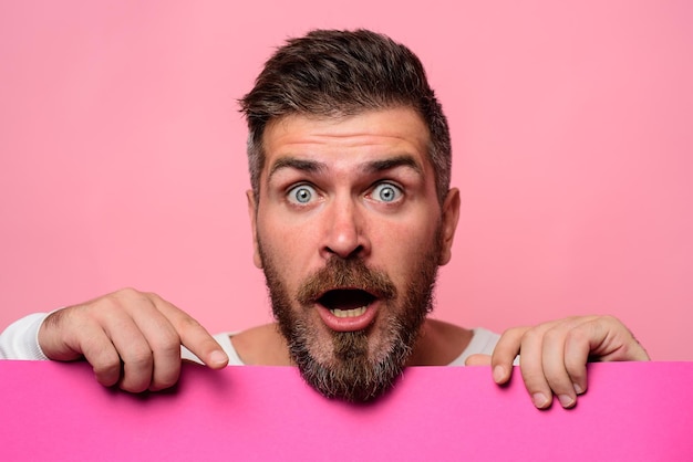 Surprised man with empty advertising banner bearded man holds board for advertising handsome man