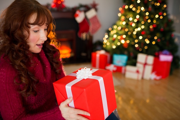 Surprised redhead holding present at christmas