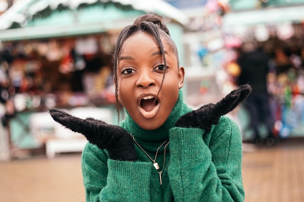 Surprised, shocked african american woman standing street outside fair xmas Christmas market posing