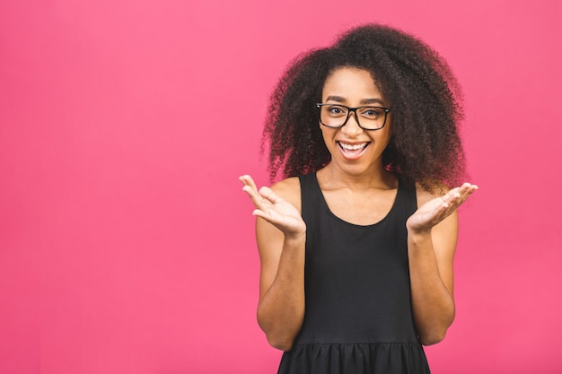 Surprised shocked amazed beautiful black woman over pink.