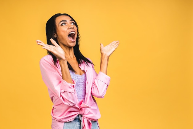 Surprised shocked amazed young african american woman stands in big shopping mall glad to see big discounts on clothes expresses shock going to spend much money today