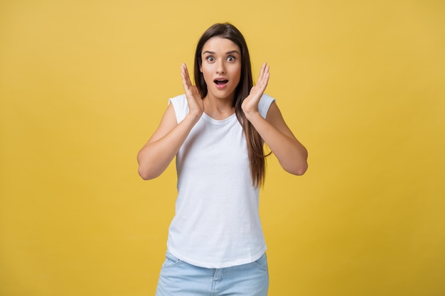 Surprised teenage girl show shocking expression with something Isolated on Bright Yellow Background Copy space