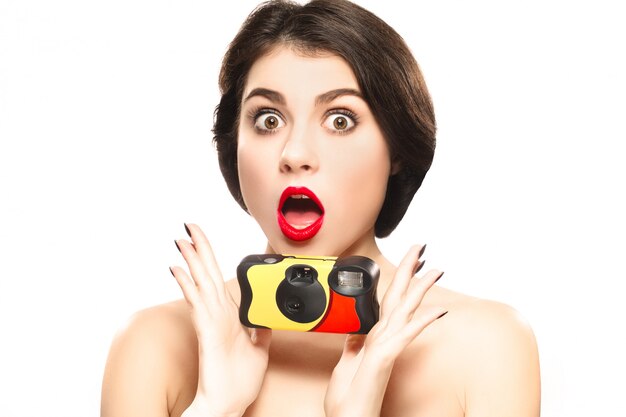 Surprised woman with camera isolated on white