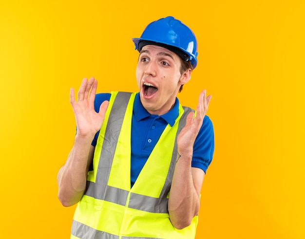 Surprised young builder man in uniform 