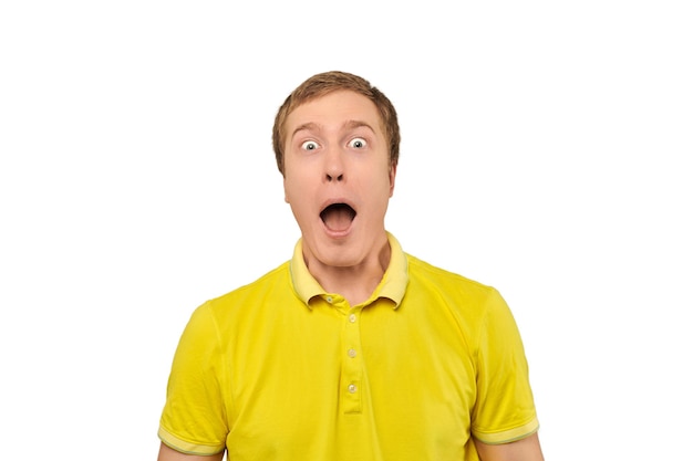 Surprised young male with funny face with wide open mouth in yellow Tshirt isolated on white