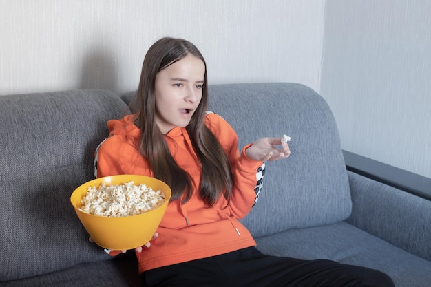 Surprised young woman watching tv news outraged