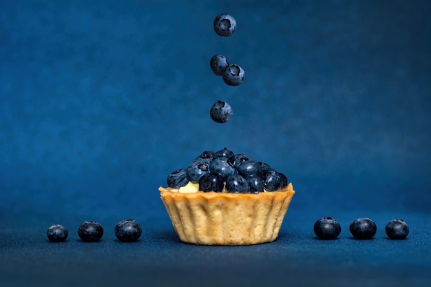 Surreal design with floating blueberry Blueberry tart Creative fly food concept Levitation berry