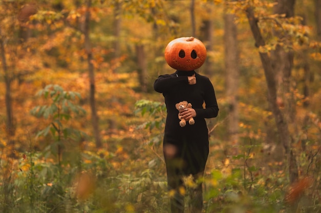 Photo surreal pumpkin head in autumn forest