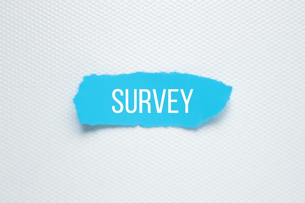 SURVEY Text on white background blue torn paper