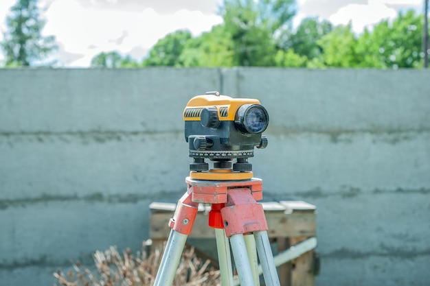 Surveying measuring equipment level transit on tripod at construction building area site