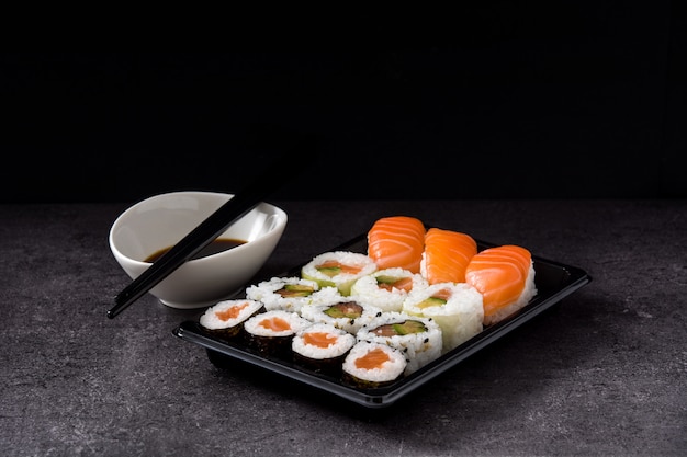 sushi assortment on black tray and soy sauce