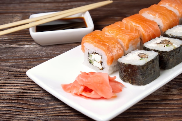 Sushi Assortment On White Dish on brown wooden table