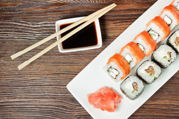 Sushi Assortment On White Dish on brown wooden table