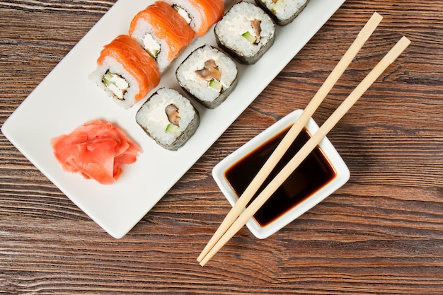 Sushi Assortment On White Dish on brown wooden table