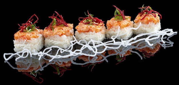 Sushi cake with salmon and Philadelphia cheese on a black glossy background with reflection